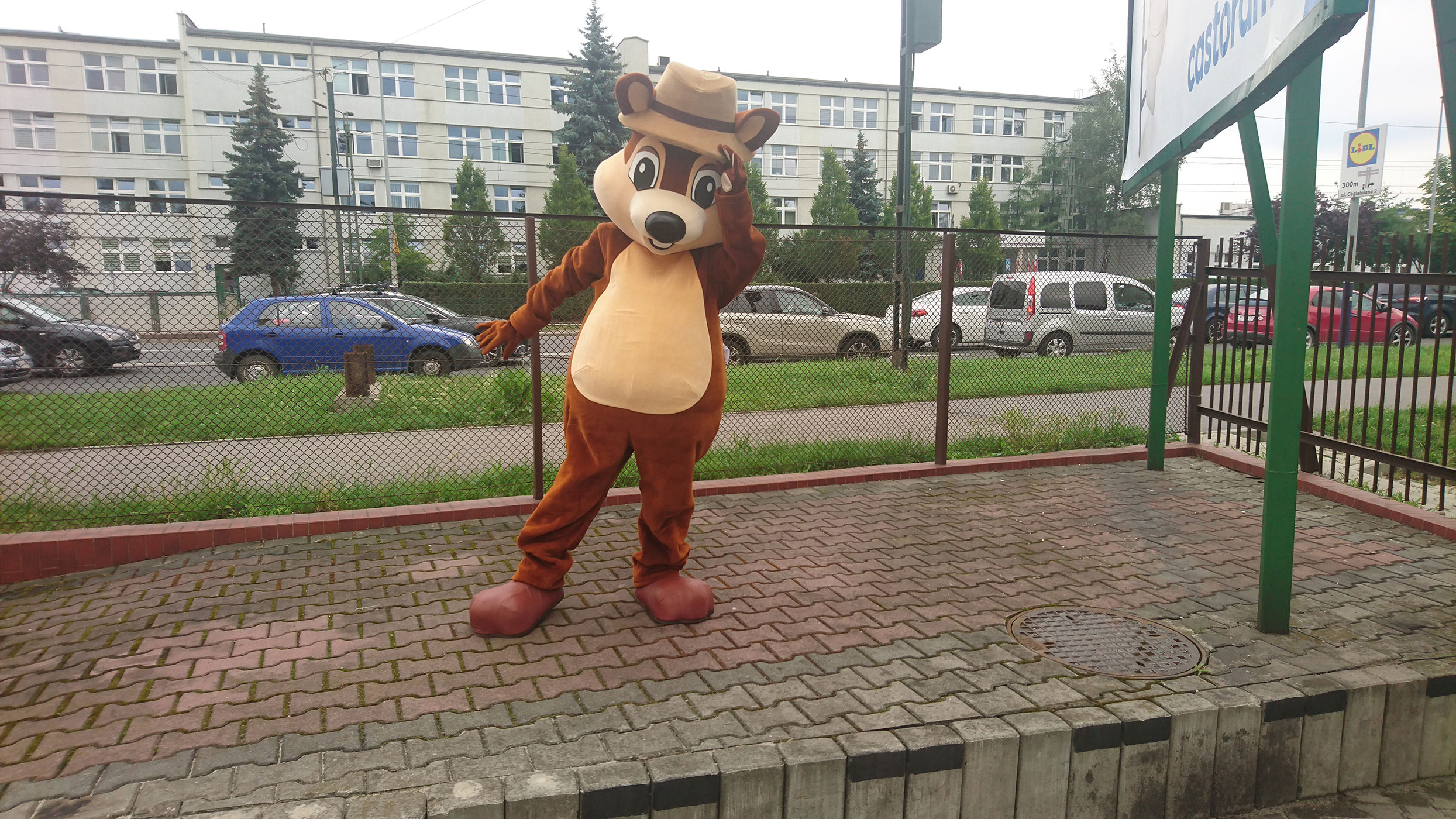 Na fotografii widnieje strój reklamowy wiewiórka pozujący do zdjęcia przed siedzibą firmy Elabika